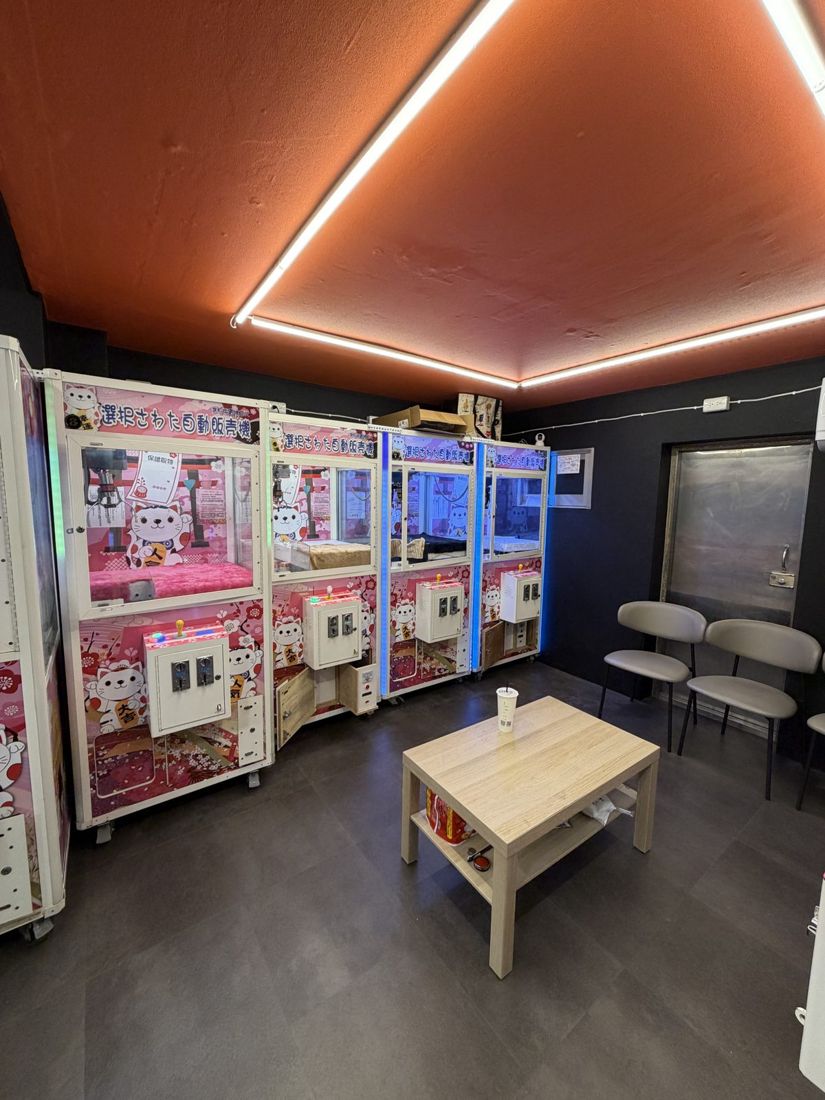 店內娃娃機排列，橘色燈條天花板